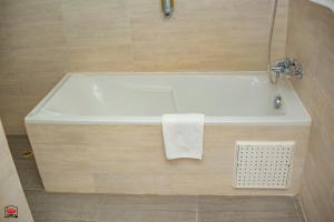 a bathroom with a bath tub with a towel on it at Mayombe Arena Hotel in Pointe-Noire