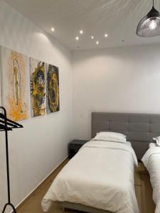 um quarto com duas camas e pinturas na parede em Proper Apartment 2 em Tirana