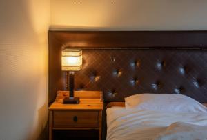 a bedroom with a bed and a lamp on a night stand at Kazimierz Secret in Kraków