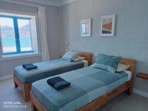 two beds in a room with a view of the ocean at Casa Manrique in Famara