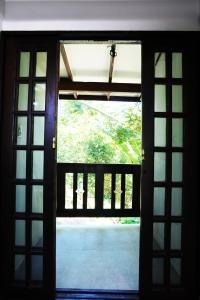 una puerta abierta con vistas a un jardín exterior en Pousada Aquarela de Bombinhas, en Bombinhas