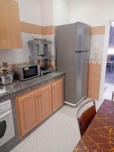 a kitchen with a stainless steel refrigerator and a microwave at أكادير حي السلام in Agadir
