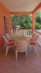 a table and chairs on a porch with a window at Apartments Igor in Bibinje