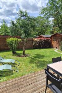 a backyard with a wooden deck with a table and chairs at Les Glazons *T4* Olivet + Parking in Olivet