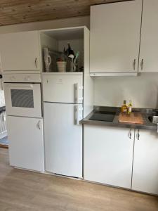 een keuken met witte apparaten en witte kasten bij Bed House By Me in Vester-Skerninge
