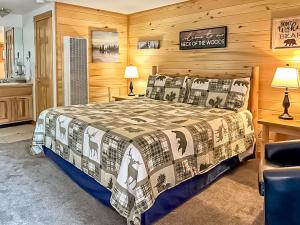 ein Schlafzimmer mit einem Bett in einem Zimmer mit Holzwänden in der Unterkunft Nicky's Resort in Estes Park