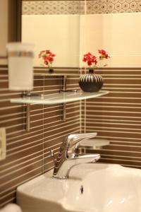 a bathroom with a sink and two shelves with flowers at Kianna Bed&Breakfast in Dorgali