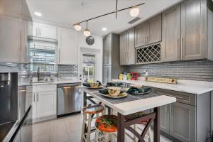 a kitchen with white cabinets and a island with a table at 509 W Olympia in Punta Gorda