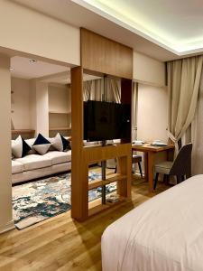 1 dormitorio con 1 cama y sala de estar con TV. en مخصص للعوائل فقط Four Elements en El Cairo