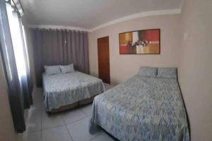 um quarto de hotel com duas camas e uma janela em Casa em Acaú/ Pitimbu PB em Pitimbu