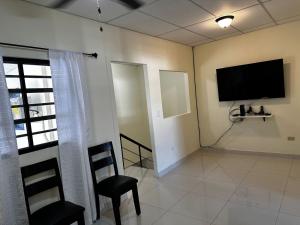 a living room with a flat screen tv on the wall at Merliot, Sta Tecla Frente Cto Comer La Plaza Merliot in Nueva San Salvador