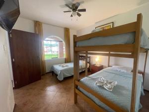 1 Schlafzimmer mit 2 Etagenbetten und einem Deckenventilator in der Unterkunft Hospedaje El Cascabel in Sunampe