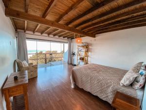a bedroom with a bed and a view of the ocean at Casa do Morro in Praia do Rosa