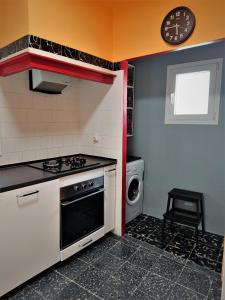 a kitchen with a stove and a washing machine at ATALAYA DEL RÍO in Valderrobres