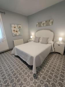 a bedroom with a large white bed in a room at ATALAYA DEL RÍO in Valderrobres