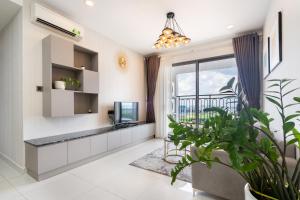 a living room with a tv and a large window at MIN' Apartment - Saigon Royal - Upscale Apartment - near Ben Thanh - Downtown in Ho Chi Minh City