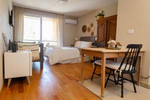 a room with a bed and a table and a bedroom at Yerba Buena Lofts - Monoambiente con Cochera in Yerba Buena