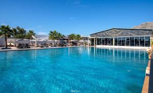 a large pool with blue water in front of a resort at Paradice Hotel Luxury Suites-Near zorbas Beach-FREE Breakfast in Stavros