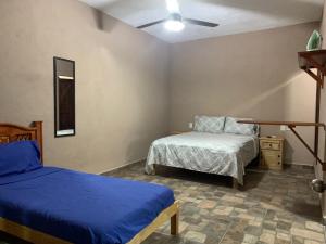 um quarto com duas camas e uma cadeira. em Bungalows Victoria em La Manzanilla