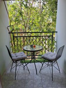 eine Terrasse mit einem Tisch und 2 Stühlen auf einem Balkon in der Unterkunft Sweet heart apartment Manja in Novi Sad