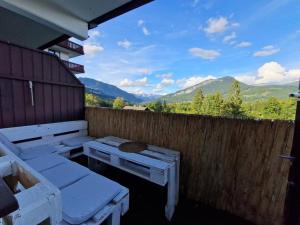 a patio with picnic tables and a fence with mountains at Appartement 214 in Bad Goisern in Bad Goisern