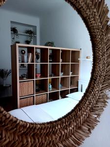 un miroir reflétant une chambre avec une étagère. dans l'établissement Sempione Studio, à Milan