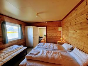 a bedroom with two beds and a window at Lydersen Rorbuer Budget Hostel & Private Apartments in Fredvang