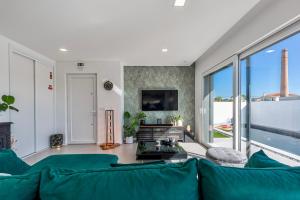 Villa Estrela في لورينها: غرفة معيشة مع أريكة زرقاء ونافذة كبيرة
