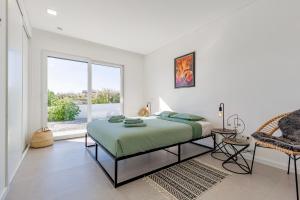 Una habitación blanca con una cama y una ventana en Villa Estrela, en Lourinhã 36 fotos más