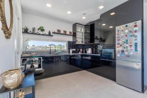 a kitchen with black cabinets and a refrigerator at Villa Estrela in Lourinhã