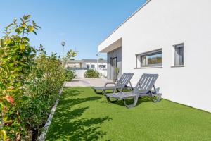 dos sillas en un césped junto a un edificio en Villa Estrela, en Lourinhã