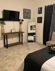 a living room with a television and a table with flowers at Luxurious 3 Story Townhome in Charlotte