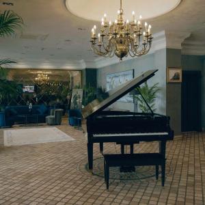 a piano in a lobby with a chandelier at The Wings Hotels Neva Palas in Ankara