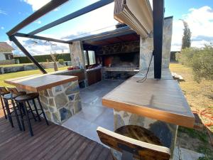 eine Terrasse mit einem Grill, einem Tisch und Stühlen in der Unterkunft La Traviesa,Villa de Lujo de 500 m. en el Campo con Piscina 