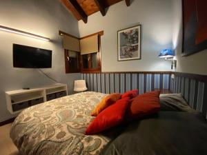 a bedroom with a bed with red pillows on it at La Traviesa,Villa de Lujo de 500 m. en el Campo con Piscina 