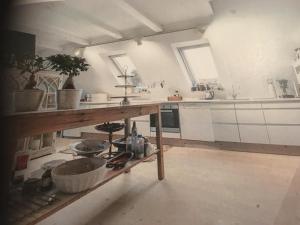 una cucina con armadi bianchi e ripiano in legno di Ebeltoft a Ebeltoft