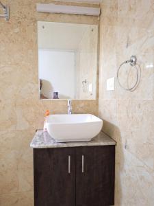 a bathroom with a sink and a mirror at Suvarna Grande Homes in Mangalore +49 photos
