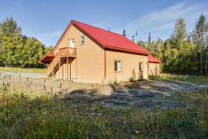 une maison avec un toit rouge sur un champ dans l'établissement Cozy Soldotna Vacation Rental Near Kenai River!, à Soldotna