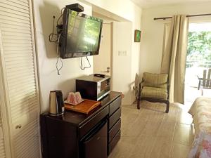 a living room with a tv on a dresser with a microwave at Mystic Ridge Apt 2 Plus 6 in Ocho Rios