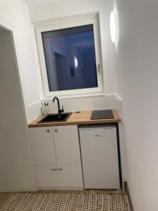 a kitchen with a sink and a window at Wein4tel-Apartments in Auersthal