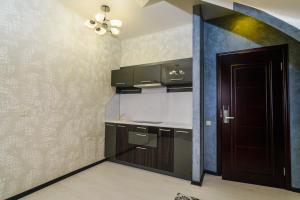 uma cozinha com armários castanhos, uma porta e um tecto em Astra Hotel em Adler