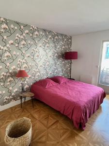 1 dormitorio con cama rosa y pared de flores en La terrasse, en Frontignan