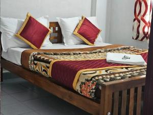 Una cama con dos almohadas encima. en Cicily Holidays Inn en Munnar
