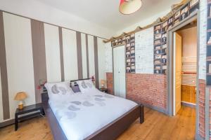 a bedroom with a bed and a brick wall at L'Escale Marine - Couette et Café in La Rochelle