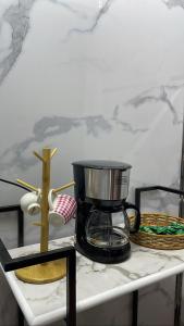 una cafetera sobre una mesa con un plato y un tazón en غرفة وصالة في أبها, en Abha