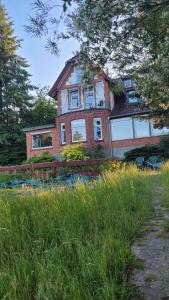 duży ceglany dom z oknami na polu trawy w obiekcie Ferienappartement im Waldhaus Göhrde w mieście Nahrendorf