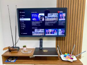 En TV eller et underholdningssystem på Apto charmoso e espaçoso no Centro, térreo com 2 Quartos ArCond WiFi HomeOfice Cozinha e Garagem