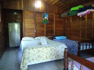 1 Schlafzimmer mit 2 Betten in einem Holzzimmer in der Unterkunft Pousada do Cowboy in Sapucaí-Mirim