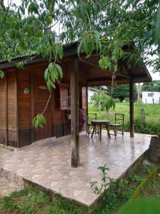 einem Pavillon mit einem Picknicktisch vor einer Hütte in der Unterkunft Pousada do Cowboy in Sapucaí-Mirim