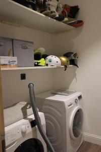 a laundry room with a washing machine and a shelf at Maison de village au coeur d'Allos in Allos +8 photos